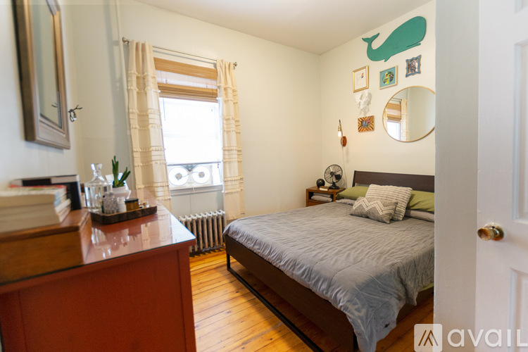 A bedroom with a bed, dresser, and mirror.