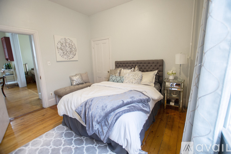 A bedroom with a large bed and a mirror on the wall.