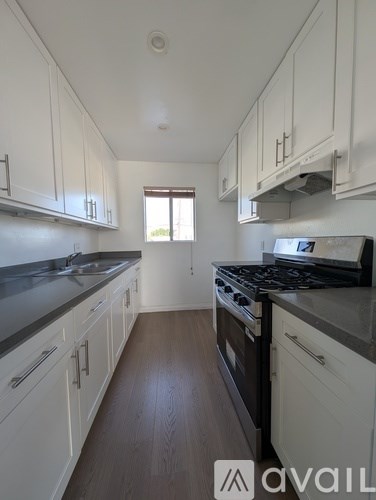 A kitchen with white cabinets and a black stove top oven.