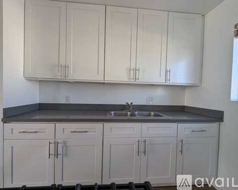 A kitchen with white cabinets and a sink.