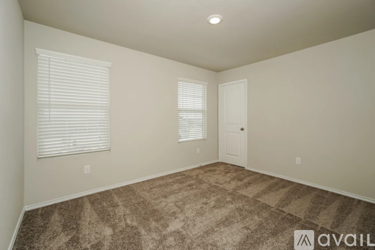 A room with carpeted floor and a door.