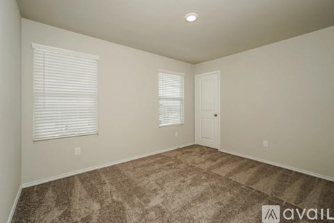 A room with carpeted floor and a door.