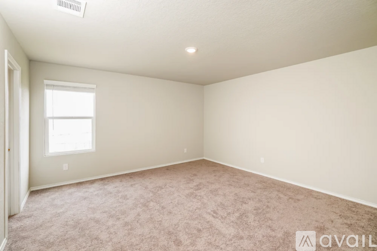 A room with a carpeted floor and a window.