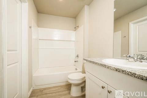 A white bathroom with a toilet, sink, and bathtub.