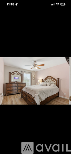 A bedroom with a large bed and a ceiling fan.