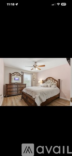 A bedroom with a large bed and a ceiling fan.