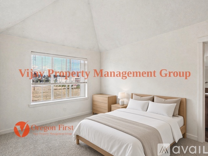 A bedroom with a large bed and a window overlooking a balcony.