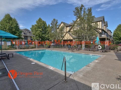 A swimming pool surrounded by a concrete patio and a large building in the background.