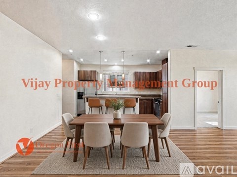 A dining room with a table set for six and a kitchen in the background.