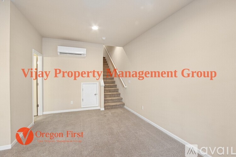 A spacious room with a staircase leading to the second floor.