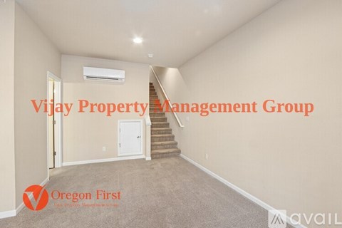 A spacious room with a staircase leading to the second floor.