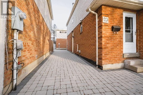 A brick building with the number 23 on the door.