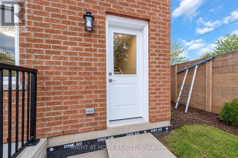A red brick house with a white door and a black gate.