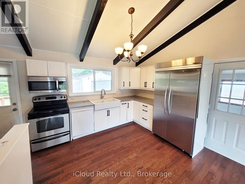 A kitchen with stainless steel appliances and wooden floors.