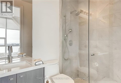 A modern bathroom with a walk-in shower and a double sink vanity.