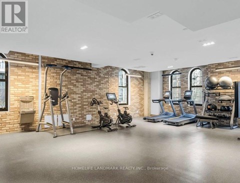 A gym with a brick wall and various exercise equipment.