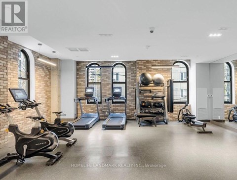 A gym with a brick wall and exercise equipment.