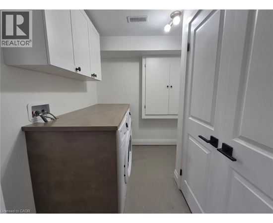 A small kitchen with white cabinets and a wooden counter.
