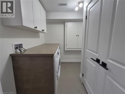 A small kitchen with white cabinets and a wooden counter.
