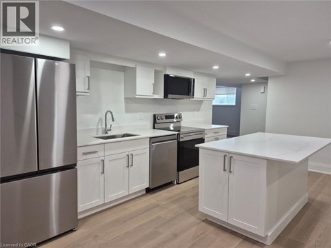 A modern kitchen with white cabinets and stainless steel appliances.