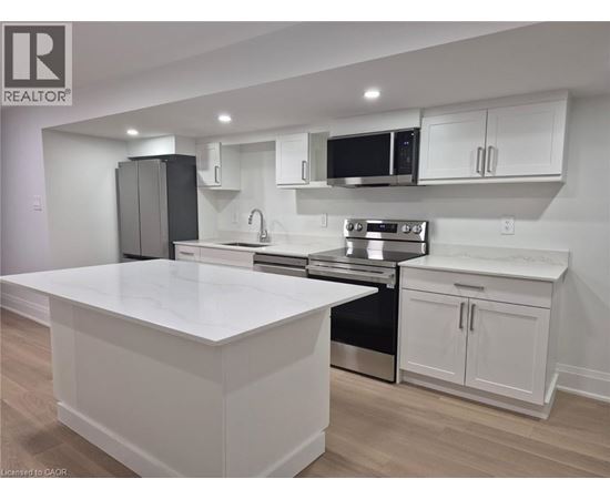 A modern kitchen with white cabinets and stainless steel appliances.