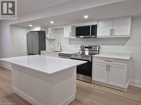 A modern kitchen with white cabinets and stainless steel appliances.