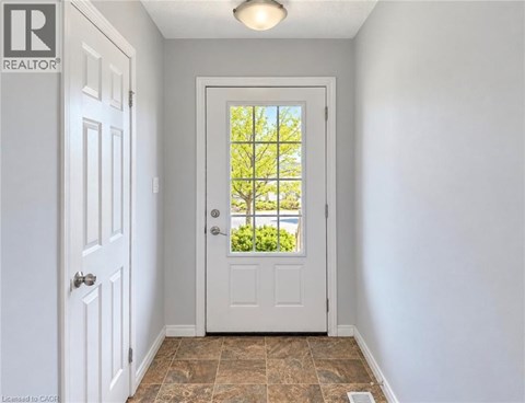 A white door with a glass window is in a room with a tiled floor.