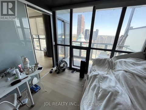 A room with a bed, a desk, and a vacuum cleaner.