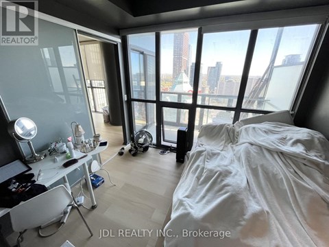 A bedroom with a large bed and a desk with a chair.