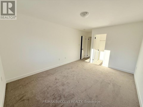 A room with a carpeted floor and a doorway leading to another room.