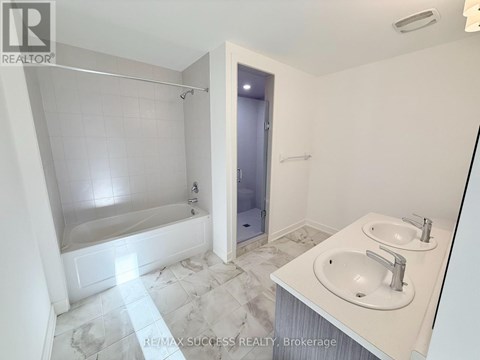 A white bathroom with a marble floor and a walk-in shower.