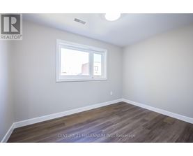 A room with a window and wooden flooring.