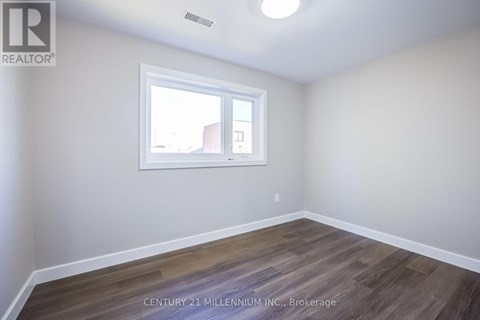 A room with a window and wooden flooring.
