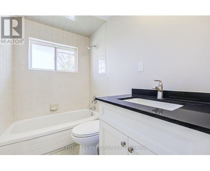 A bathroom with a white tub, sink, and toilet.