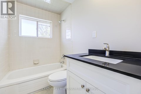 A bathroom with a white tub, sink, and toilet.
