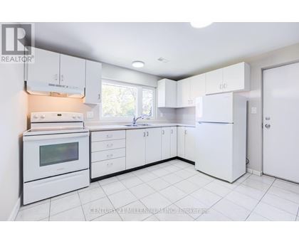 A white kitchen with a microwave, oven, and refrigerator.