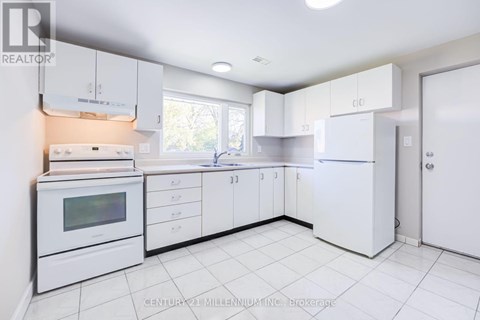 A white kitchen with a microwave, oven, and refrigerator.
