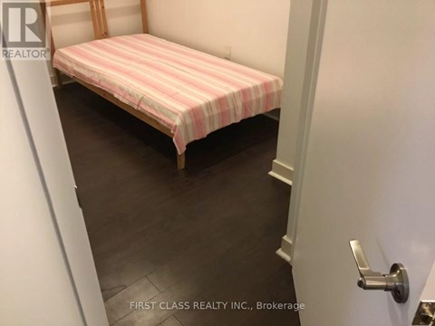 A bed with a striped pink and white cover sits in a small room.