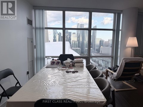 A conference room with a long table and chairs, a lamp, and a view of the city through the windows.