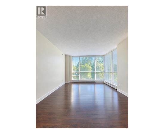 A room with wooden floors and a large window.