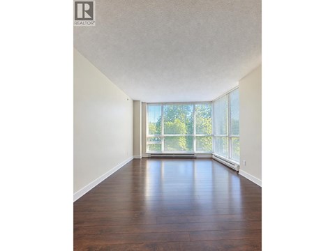 A room with wooden floors and a large window.