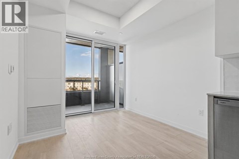 A spacious room with a sliding glass door leading to a balcony.