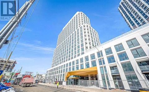 A modern building with a glass facade stands tall in an urban setting.