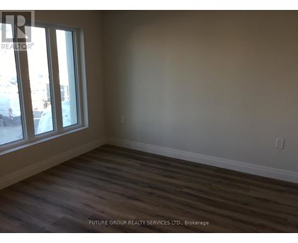 A room with wooden flooring and a window overlooking a parking lot.