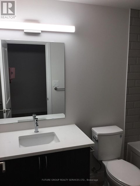 A bathroom with a sink, toilet and mirror.