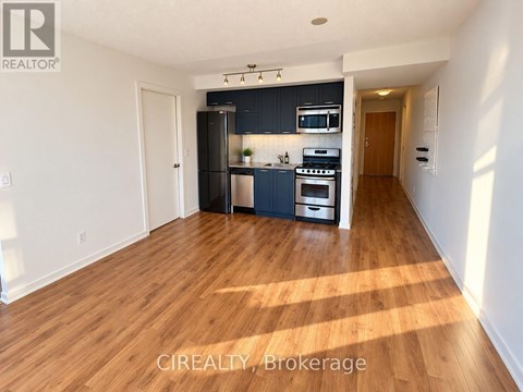 A kitchen with wooden floors and white walls.