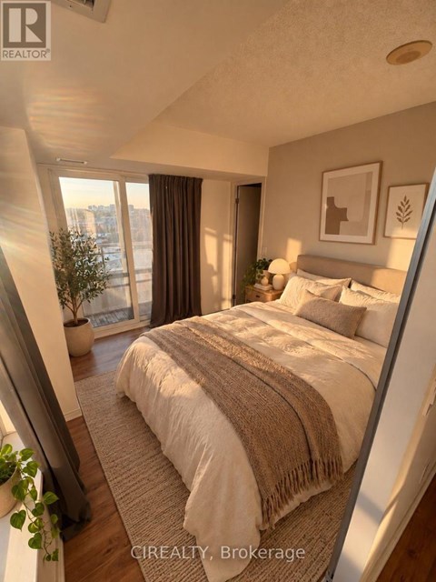 A bedroom with a large bed and a view of the city.