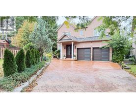 A house with a driveway and garage doors is for sale.