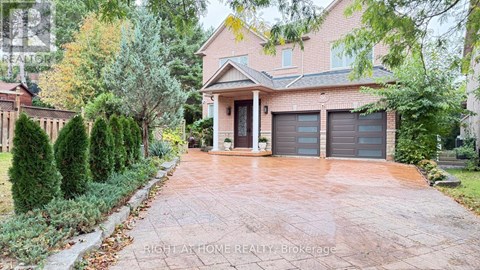 A house with a driveway and garage doors is for sale.