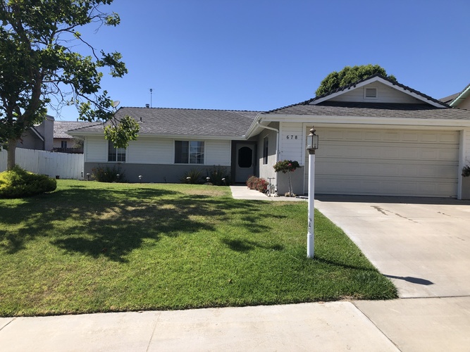 A house with a garage and a driveway in front.